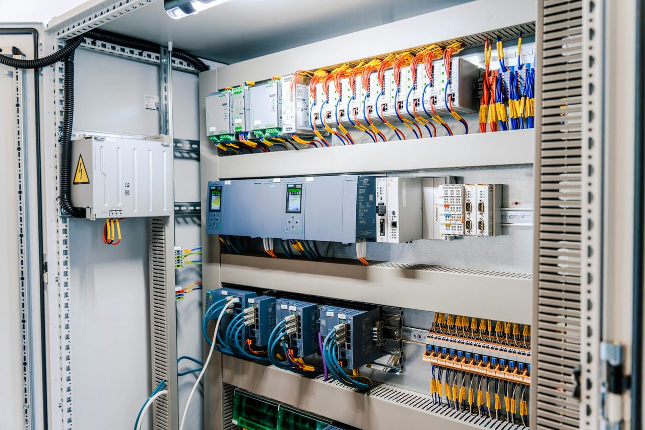 Geöffneter Schaltschrank mit SPS-Steuerung, Netzteilen, Netzwerk-Switches und Klemmenreihen